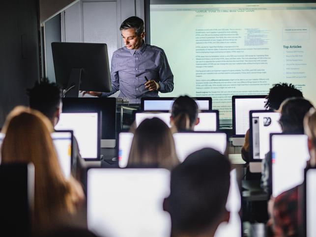 A professor teaches from the front of class