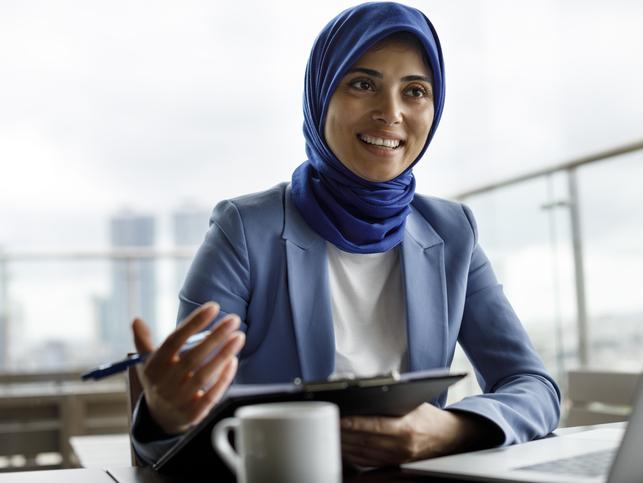 A woman wearing a headscarf in an office