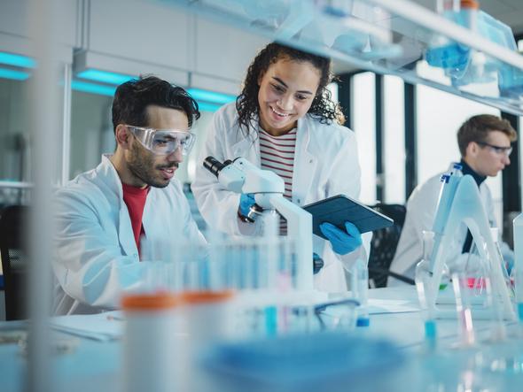 Researchers work together over a microscope