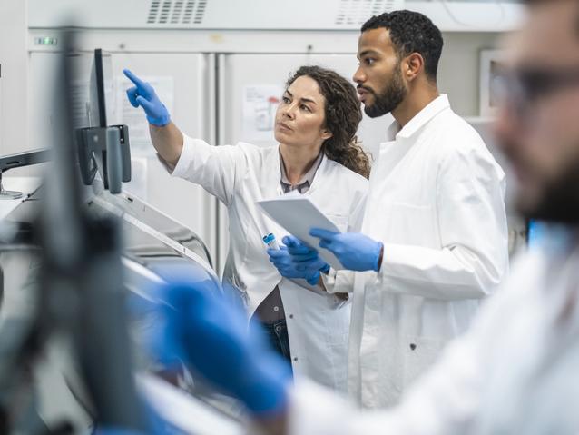 Two lab workers discussing something on a screen
