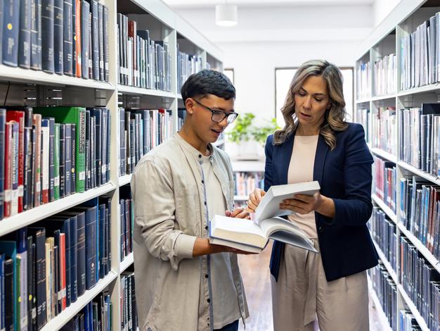 A teacher advising a student on a reading in the library