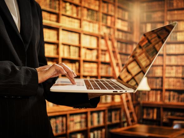 A researcher uses a laptop inside the library