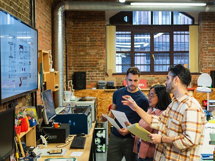 Three people working in an industrial design studio