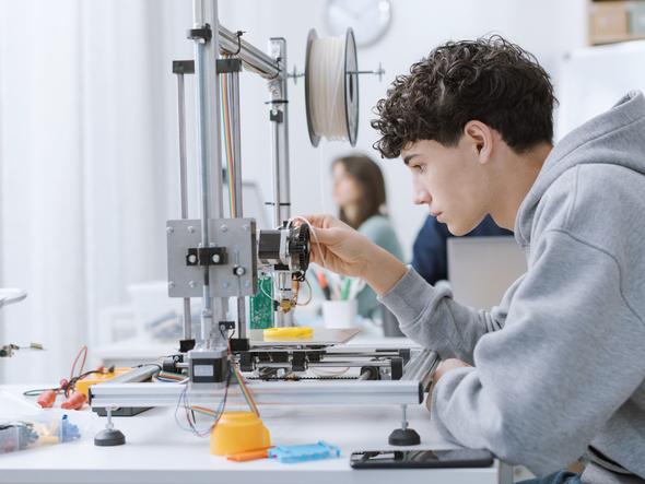 An engineering student fixing a machine in class