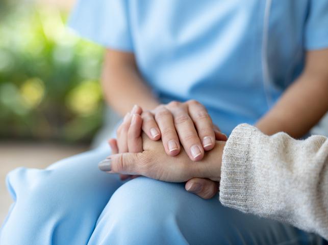 One person holds another's hand
