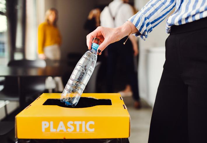 A plastic bottle is placed in a recycling bin
