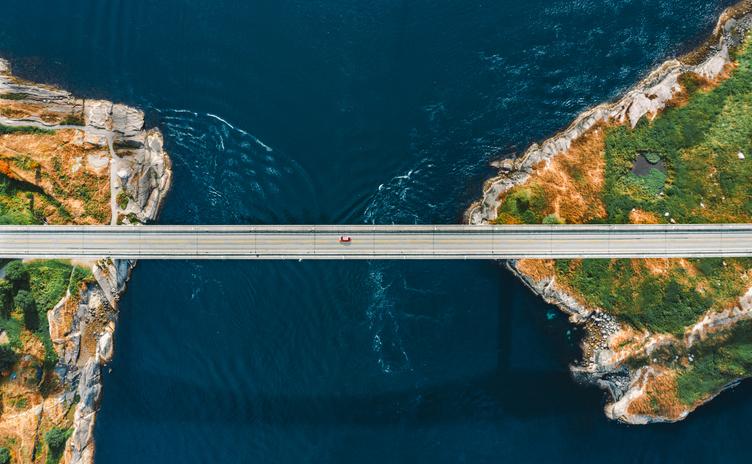 A car driving on a bridge across the sea