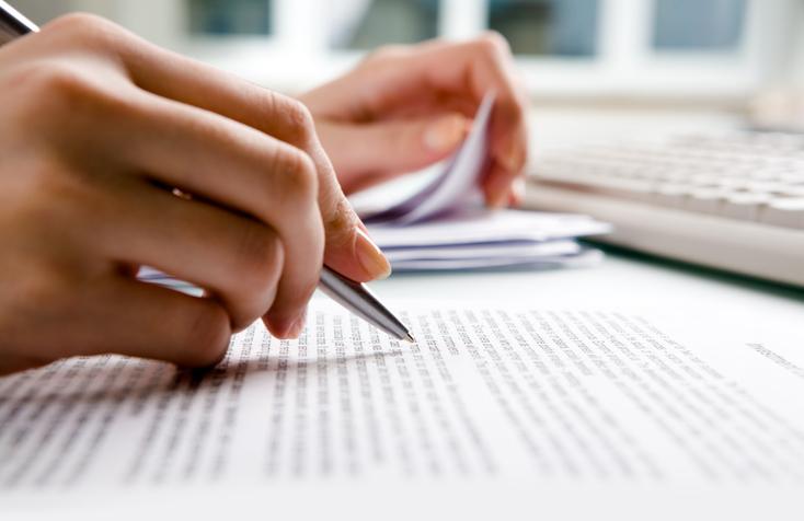 A close up of a hand working on a document