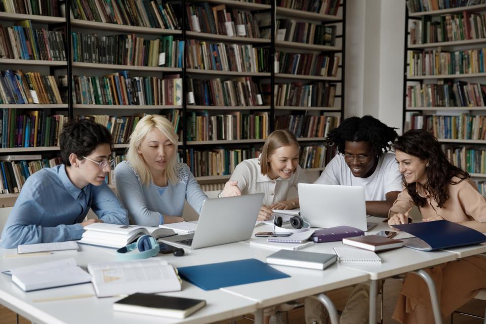 A group of students on their laptops in the library