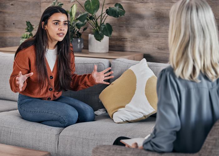 A young woman talks to a therapist earnestly