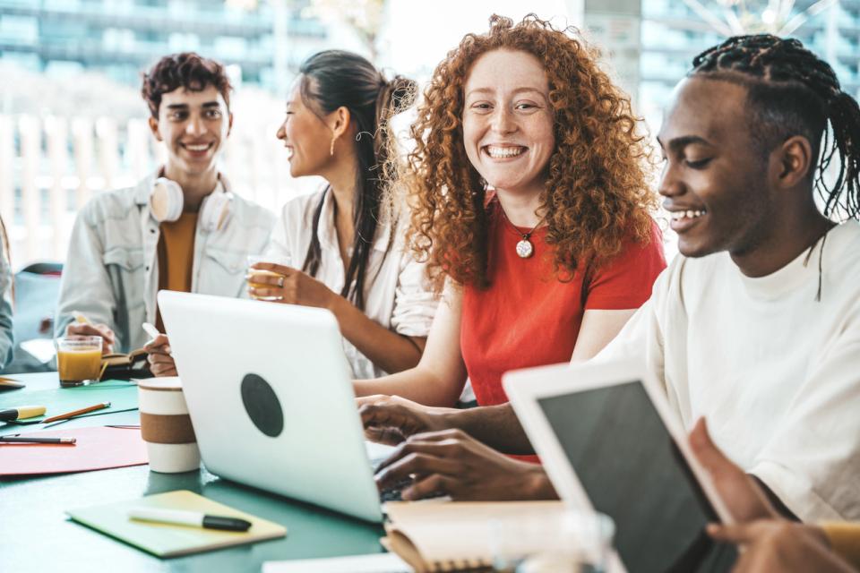 Students in a classroom smiling to camera
