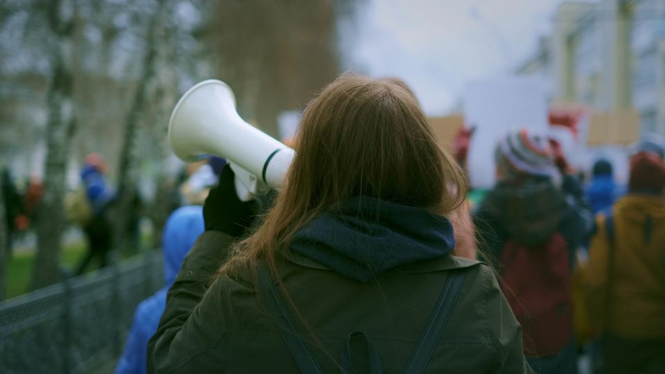 A woman holding a megaphone while protesting