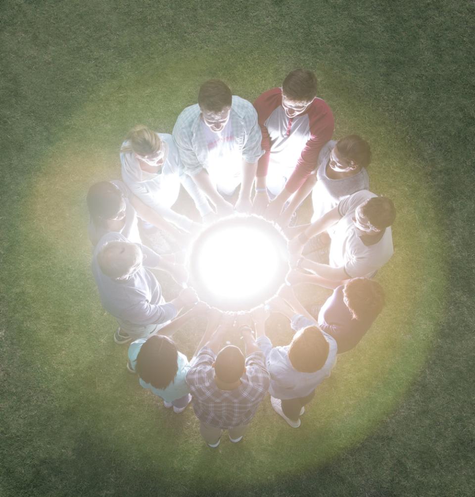 Students holding hands around a glowing orb