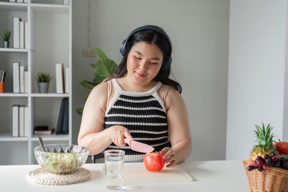 Student with headphones preparing food