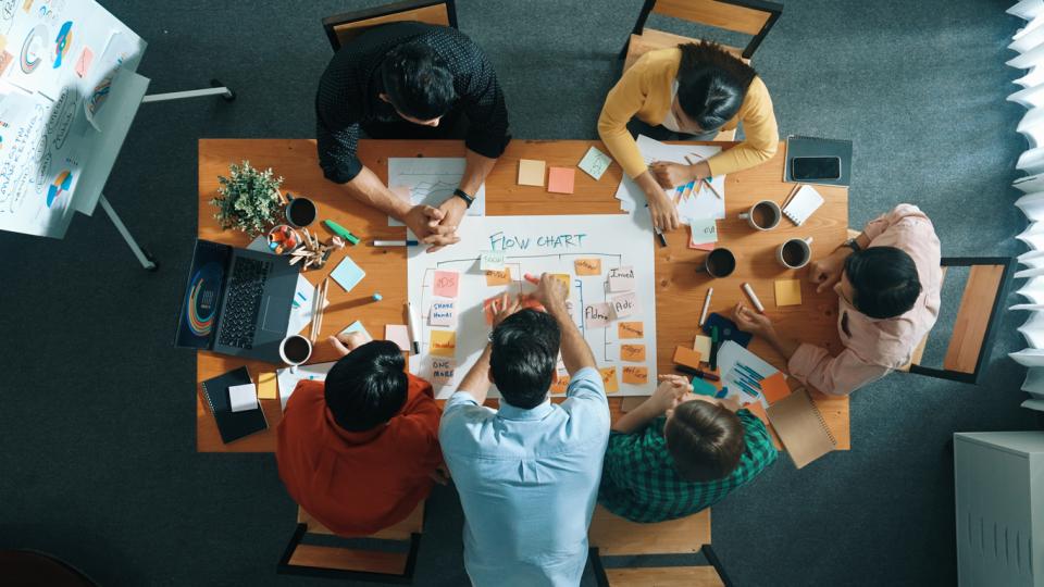 Top down view of colleagues sat around a table planning