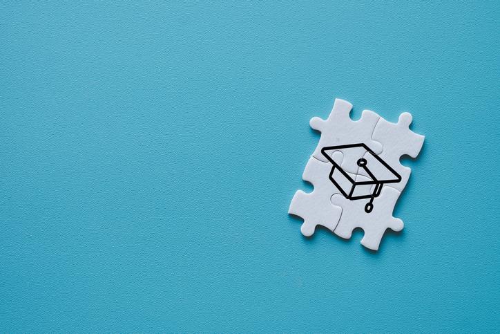 Four jigsaw puzzle pieces display a mortarbord