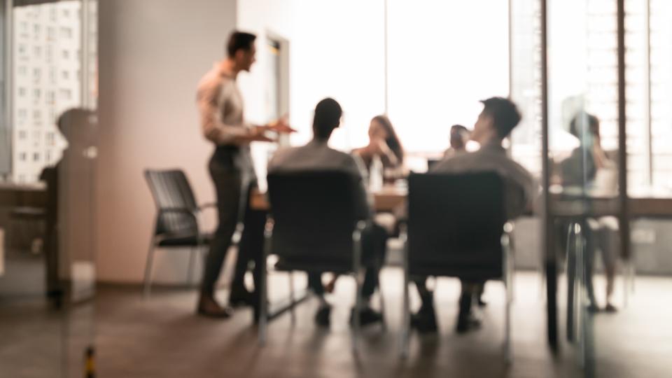 employees sitting at a boardroom table