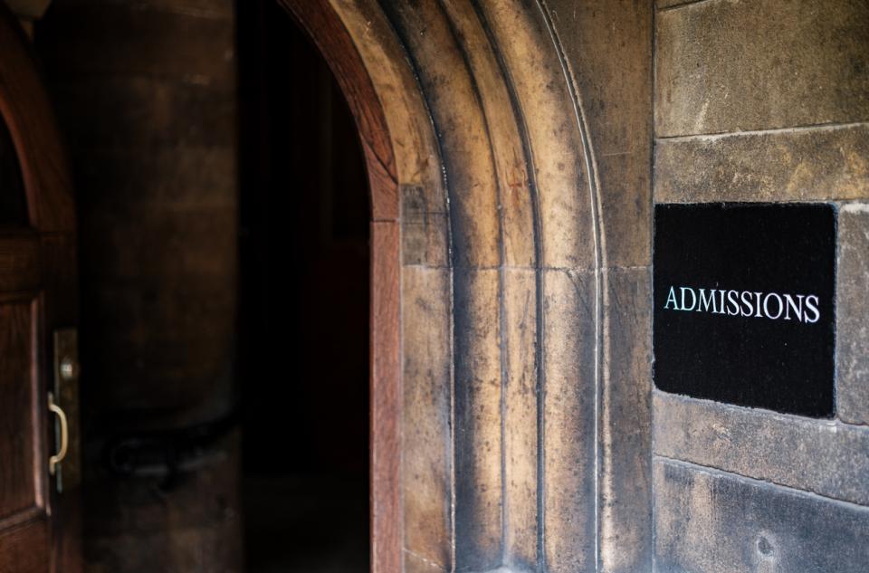 A doorway with an "admissions" sign next to it