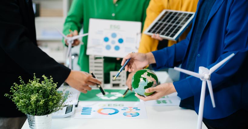 Students work with plants, a model of the Earth and a solar panel around a table