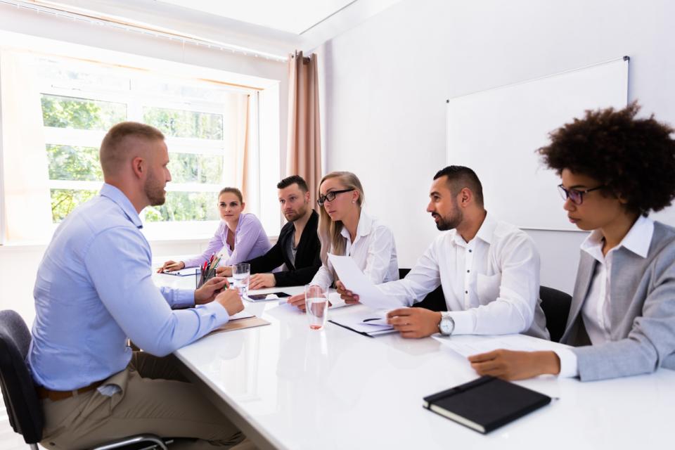 A hiring panel interviewing a candidate at a table