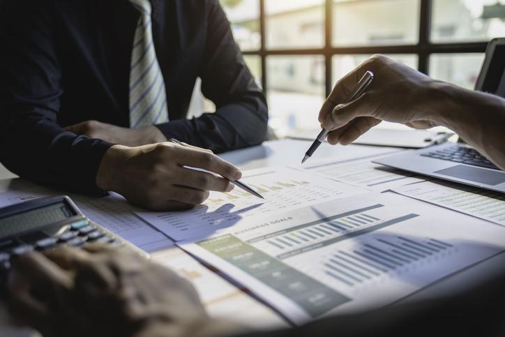 Academics sit round a table, analysing documents