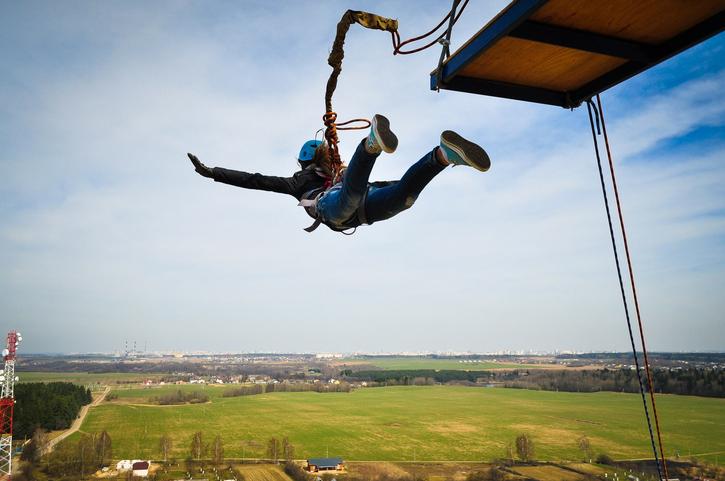 A bungee jumper leaps from a platform