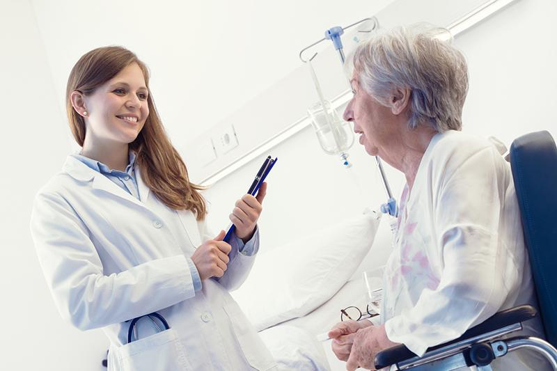 Young female medical researcher with elderly female patient