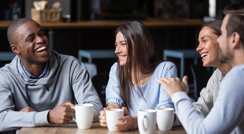 Students laugh over a coffee