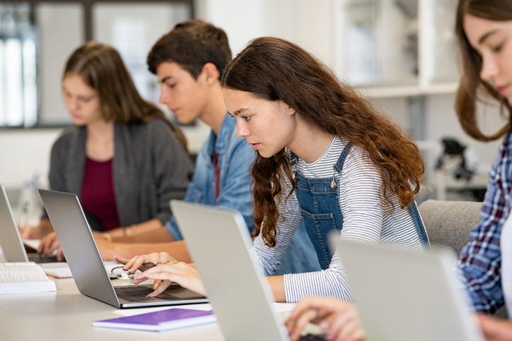 Students use their laptops in class, looking focused