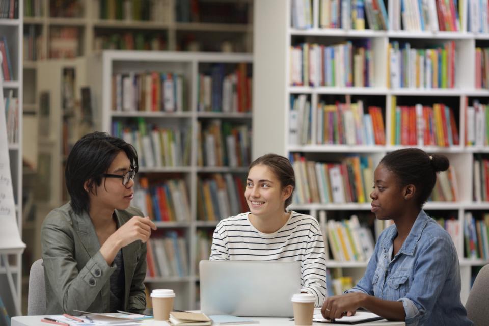 Three students working together in a library
