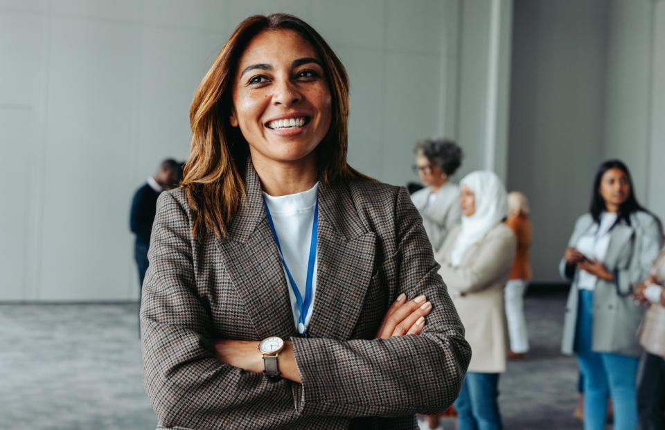 A woman in professional attire smiling to camera