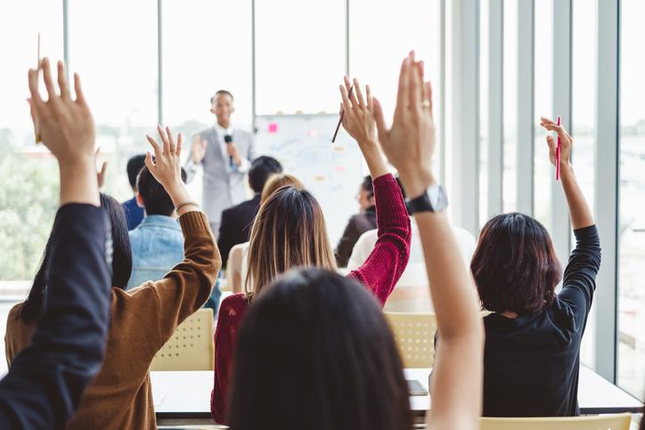 Participants in a seminar raise their hands