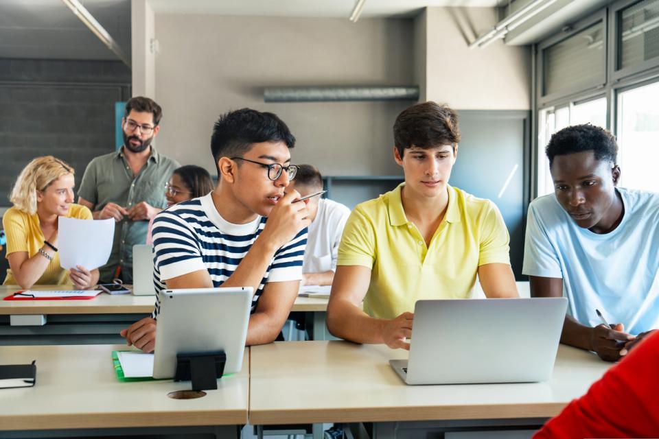 A group of students at a table looking at their screens