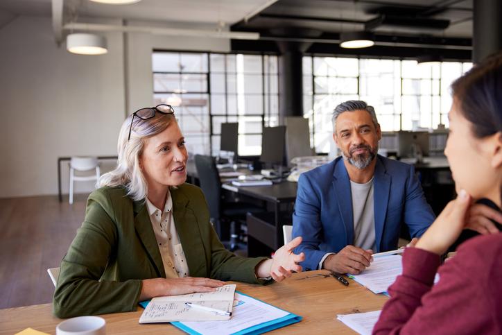 Office workers discuss around a meeting table