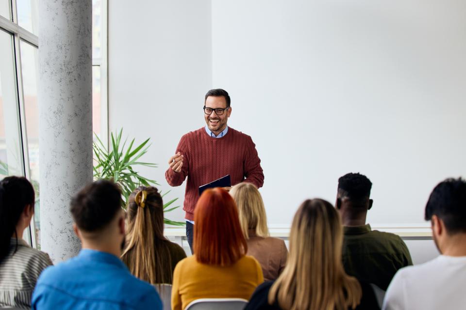A lecturer giving an engaging presentation in front of a class full of students