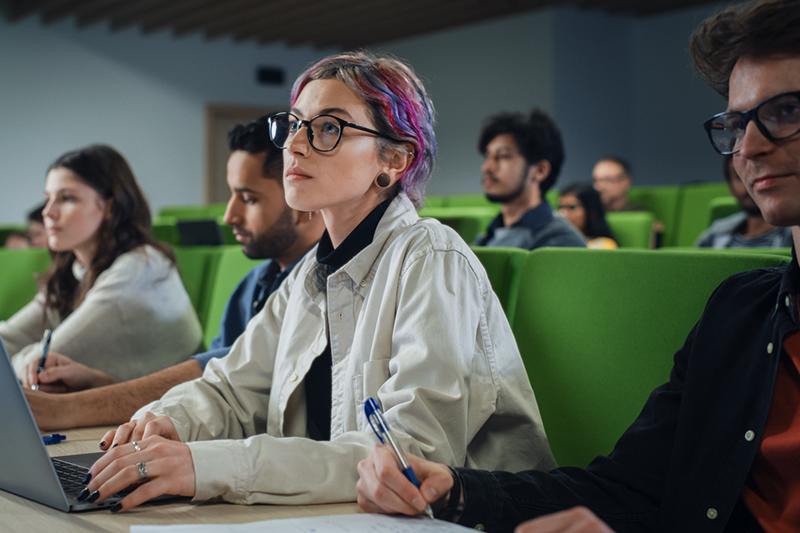 Woman with coloured hair in lecture hall