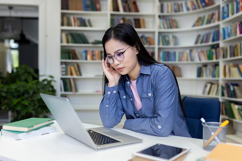 Young Asian woman concentrating working at laptop