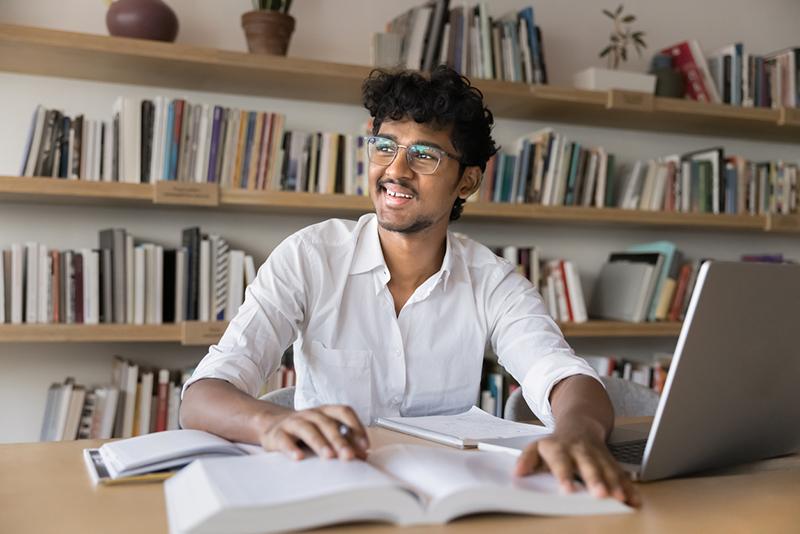 Male South Asian student in university library