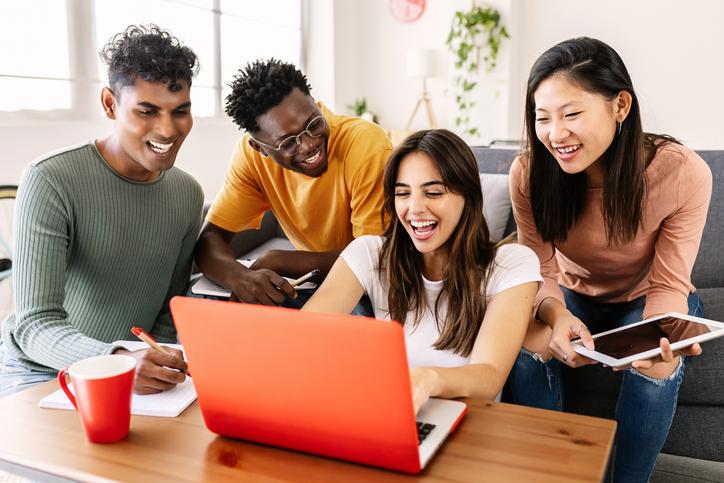 Students gather round a laptop together