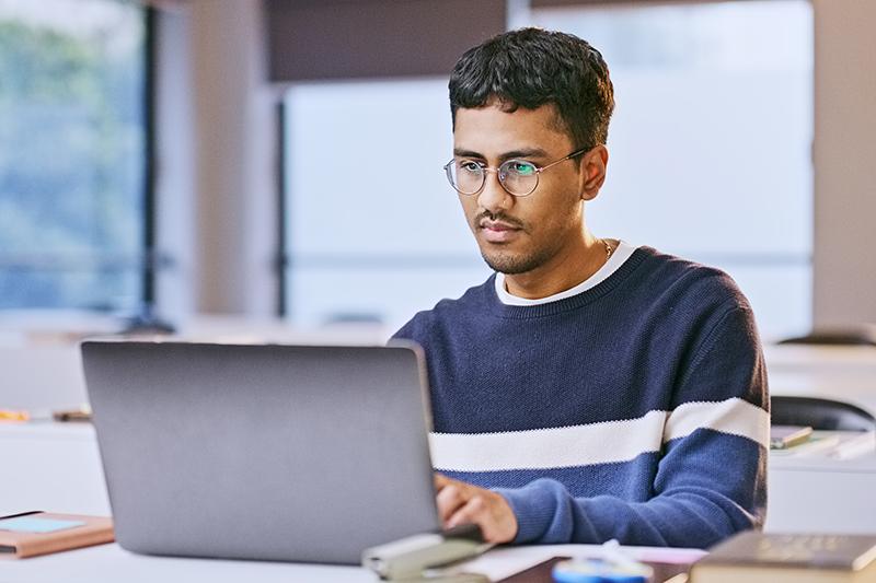 Asian man working at laptop