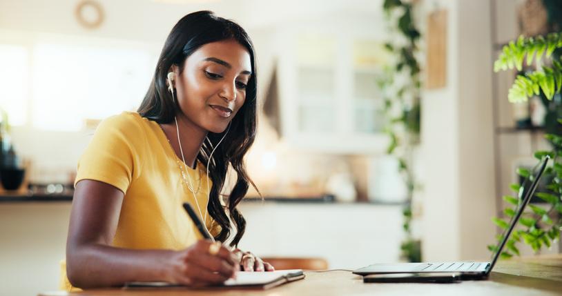 A student wearing earphones on her laptop