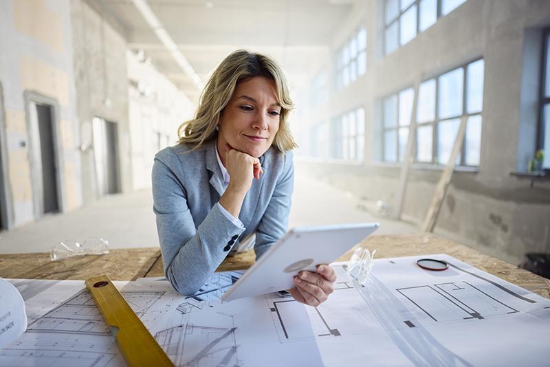 Female architect looking at plans on site