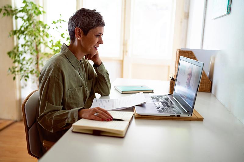 female mature-age online student working at laptop