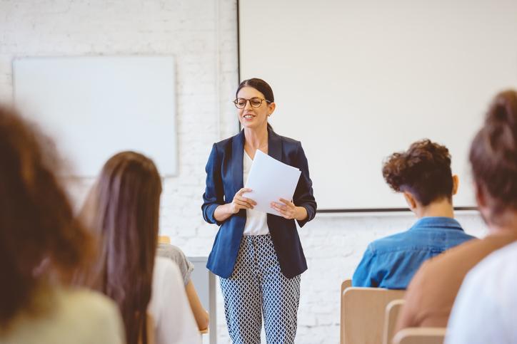 A teacher stands in front of class