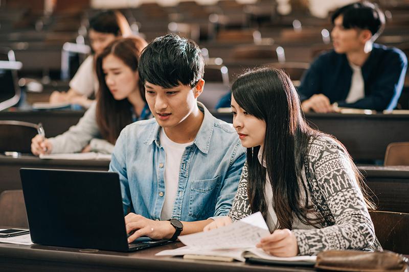 Asian students doing pair work in a lecture hall