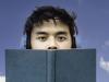 Young man in headphones holding a book