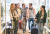 A group of students arriving on campus with suitcases
