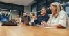 People laugh round a boardroom table