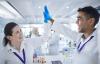 Two researchers in white coats high five