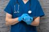 A doctor takes notes on a clipboard